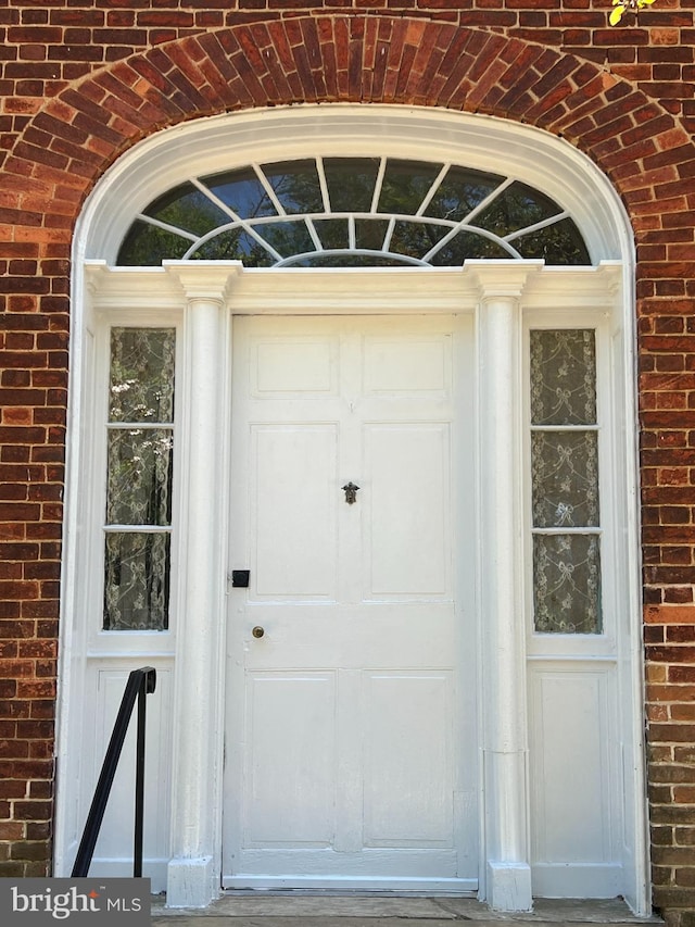 entrance to property featuring brick siding