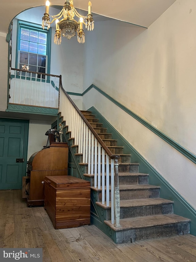 staircase featuring a chandelier and hardwood / wood-style flooring