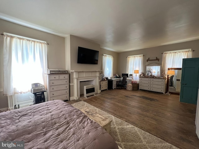 bedroom with wood finished floors and a fireplace