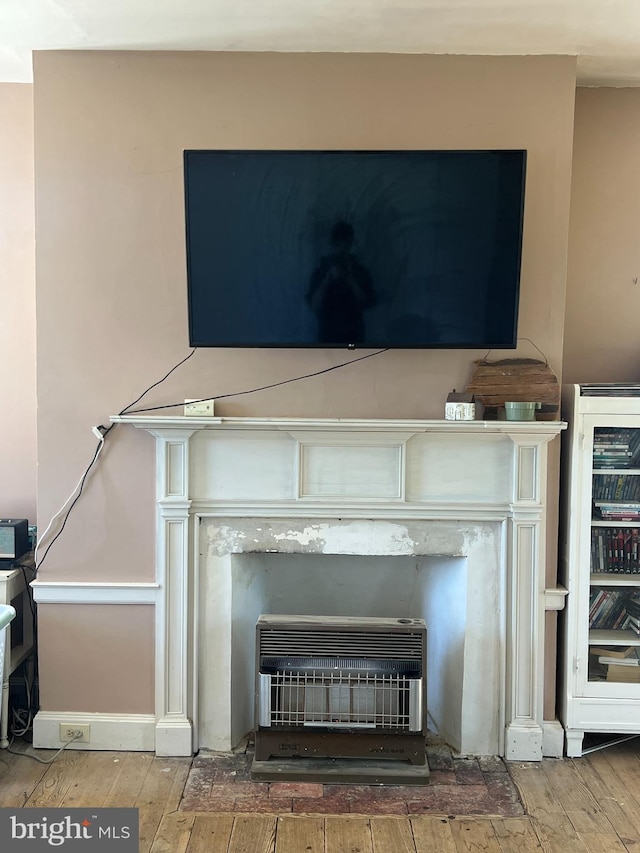 detailed view of heating unit, wood finished floors, and wine cooler