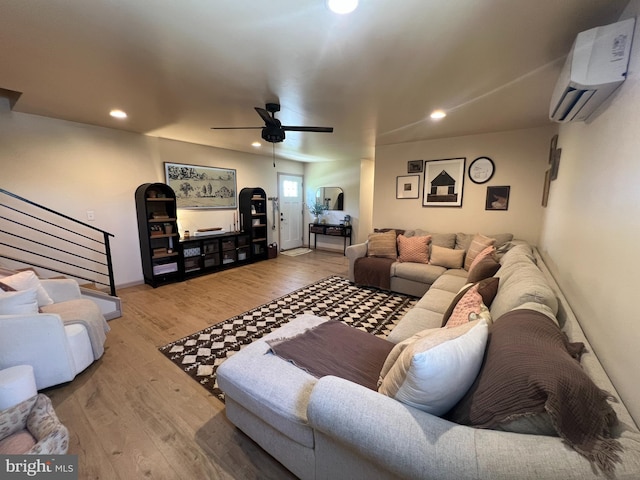 living room featuring a wall mounted AC, ceiling fan, recessed lighting, wood finished floors, and stairs
