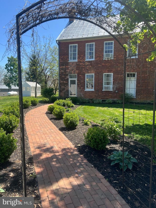 view of side of home featuring brick siding and a lawn