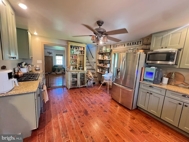 kitchen with appliances with stainless steel finishes, wood finished floors, ceiling fan, and gray cabinetry