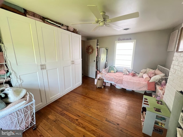 bedroom with hardwood / wood-style flooring, multiple windows, a ceiling fan, and a closet