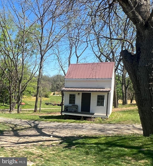 view of front of house with an outdoor structure, a front yard, and metal roof