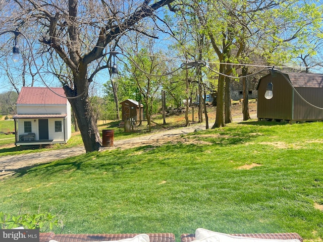 view of green lawn with a shed and an outdoor structure