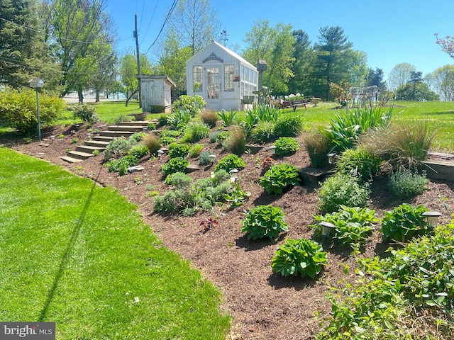 view of grassy yard featuring an outbuilding and a storage unit
