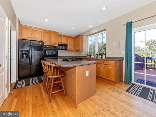 4 Jeffrey Ln, Brunswick, MD 21758 - kitchen featuring black appliances, light wood finished floors, a kitchen island, recessed lighting, and a breakfast bar area