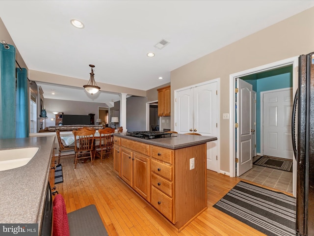 4 Jeffrey Ln, Brunswick, MD 21758 - kitchen with dark countertops, light wood-style floors, open floor plan, black appliances, and a center island