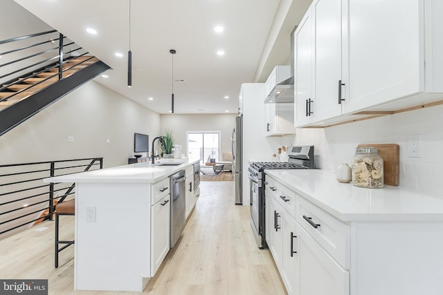 3221 Mercer St, Philadelphia, PA 19134 - kitchen featuring appliances with stainless steel finishes, a sink, light wood-style flooring, an island with sink, and a breakfast bar area