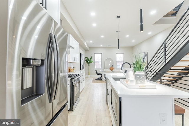 3221 Mercer St, Philadelphia, PA 19134 - kitchen with stainless steel appliances, a sink, a center island with sink, white cabinetry, and light countertops