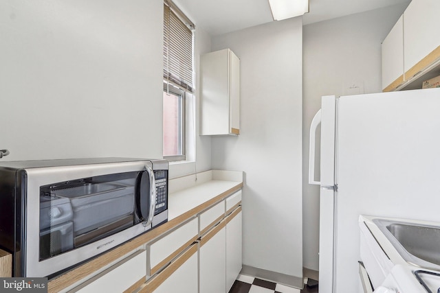 1111 Arlington Blvd Unit 810, Arlington, VA 22209 - kitchen featuring stainless steel microwave, white cabinetry, light countertops, and tile patterned floors