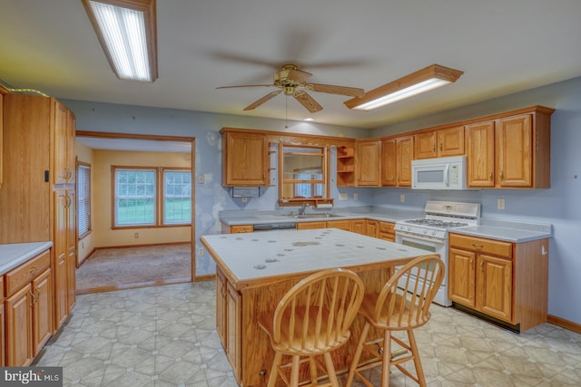 74 Connie Ln, Dover, DE 19901 - kitchen featuring white appliances, a sink, a kitchen island, ceiling fan, and baseboards