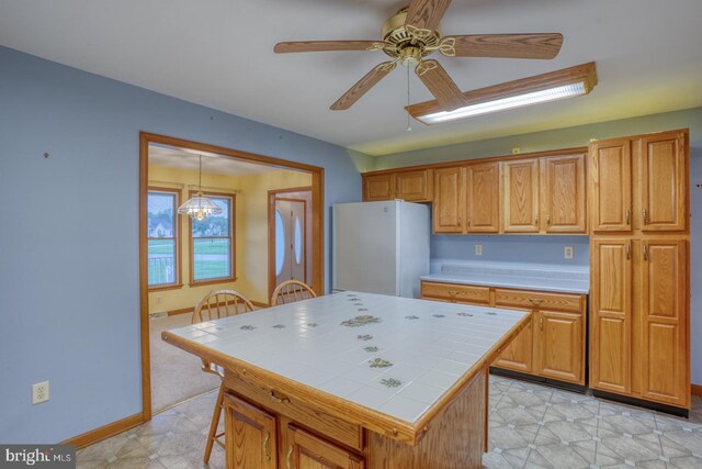 74 Connie Ln, Dover, DE 19901 - kitchen featuring tile counters, freestanding refrigerator, ceiling fan, baseboards, and brown cabinetry