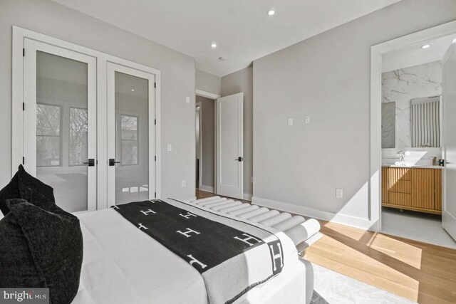bedroom featuring wood finished floors, recessed lighting, french doors, baseboards, and connected bathroom
