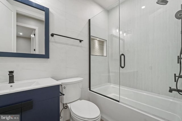 full bath with vanity, bath / shower combo with glass door, and toilet