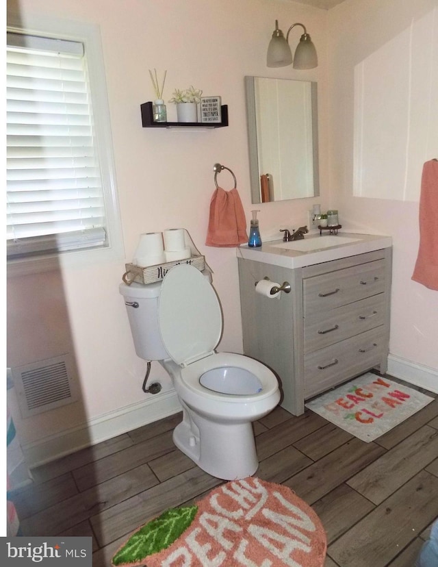 3016 Pennsylvania Ave, Lansdowne, MD 21227 - bathroom with wood finished floors, toilet, vanity, and baseboards