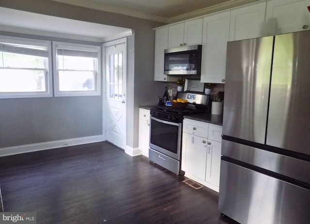 3016 Pennsylvania Ave, Lansdowne, MD 21227 - kitchen featuring appliances with stainless steel finishes, dark countertops, ornamental molding, dark wood-type flooring, and white cabinets