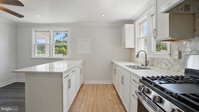8014 Ritchie Hwy, Pasadena, MD 21122 - kitchen featuring gas stove, a sink, a peninsula, crown molding, and extractor fan