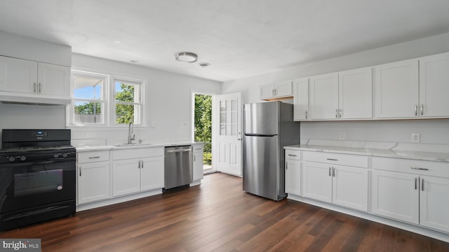 8014 Ritchie Hwy, Pasadena, MD 21122 - kitchen featuring stainless steel appliances, a sink, white cabinets, under cabinet range hood, and dark wood-style floors