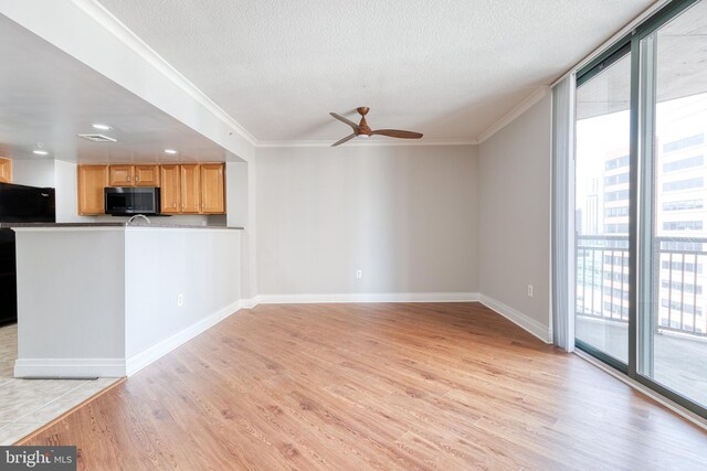 414 Water St Unit 1704, Baltimore, MD 21202 - unfurnished living room with crown molding, light wood-type flooring, a ceiling fan, a textured ceiling, and baseboards