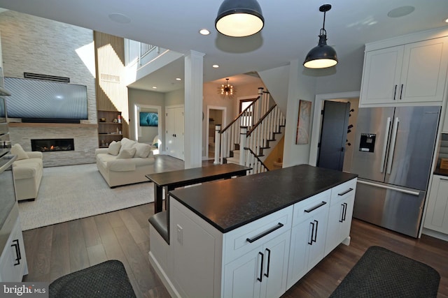 7012 Silverwood St, Philadelphia, PA 19128 - kitchen with stainless steel fridge, dark countertops, dark wood finished floors, open floor plan, and recessed lighting