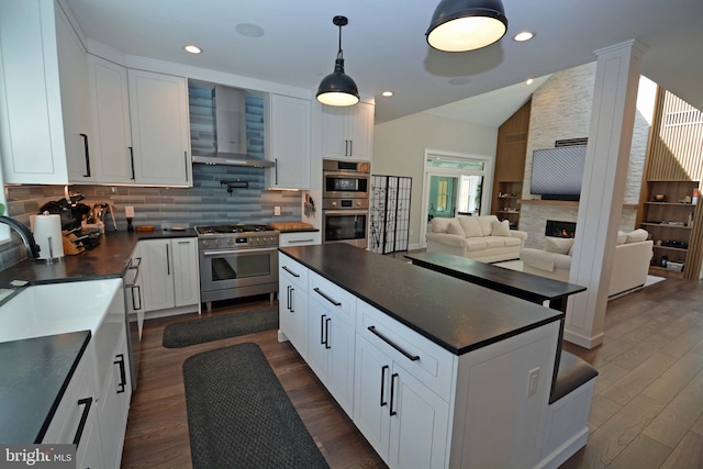 7012 Silverwood St, Philadelphia, PA 19128 - kitchen with appliances with stainless steel finishes, dark countertops, wall chimney range hood, vaulted ceiling, and decorative backsplash