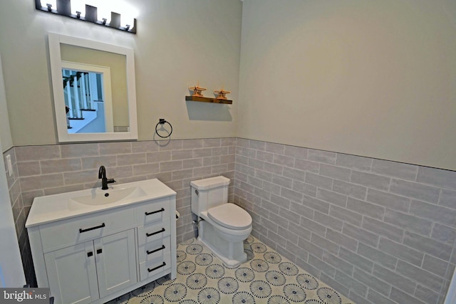 7012 Silverwood St, Philadelphia, PA 19128 - half bathroom with tile walls, toilet, vanity, a wainscoted wall, and tile patterned floors