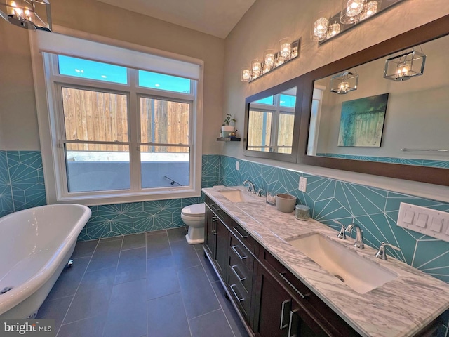 7012 Silverwood St, Philadelphia, PA 19128 - bathroom featuring tile walls, tile patterned floors, a soaking tub, a wainscoted wall, and toilet