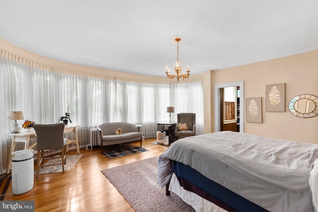 bedroom with a chandelier and wood finished floors