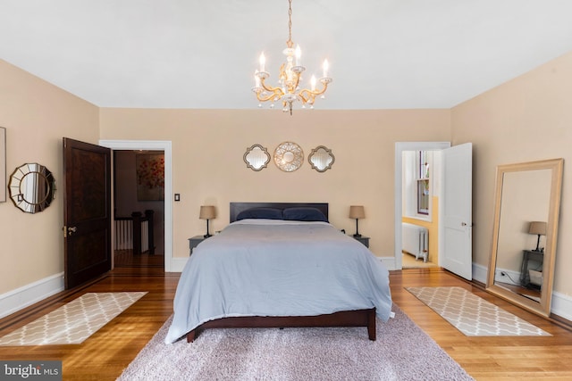 bedroom with radiator heating unit, a chandelier, wood finished floors, and baseboards