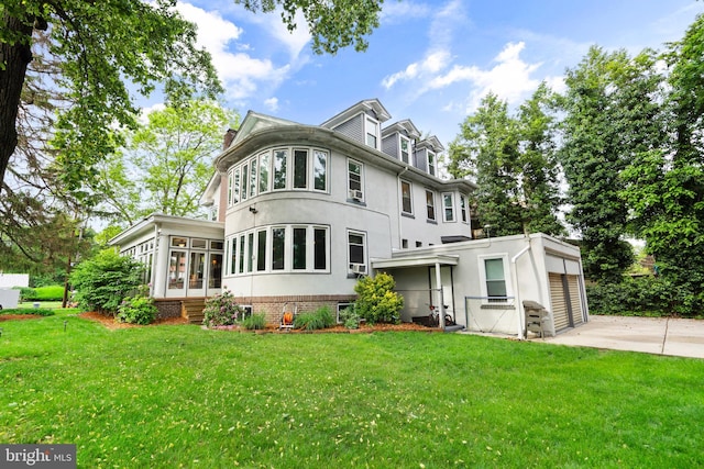 view of front of house featuring concrete driveway, a garage, a front yard, a chimney, and stucco siding