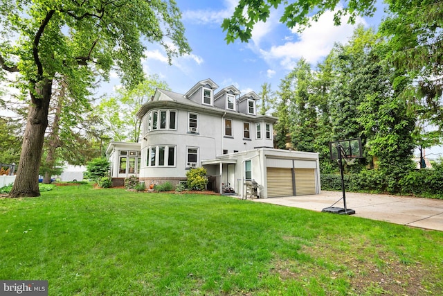 view of front facade featuring stucco siding, a front lawn, and driveway