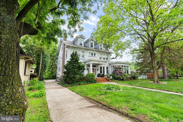 view of front facade with a front yard and a chimney