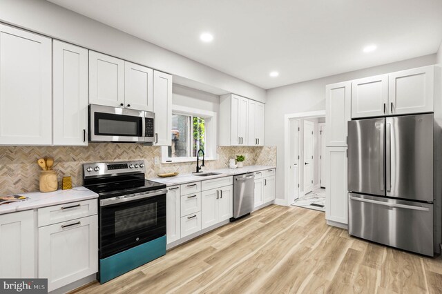 5113 W Thompson St, Philadelphia, PA 19131 - kitchen featuring appliances with stainless steel finishes, a sink, white cabinetry, tasteful backsplash, and recessed lighting