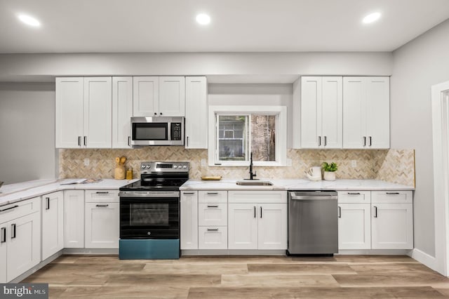 5113 W Thompson St, Philadelphia, PA 19131 - kitchen featuring stainless steel appliances, a sink, recessed lighting, white cabinets, and backsplash