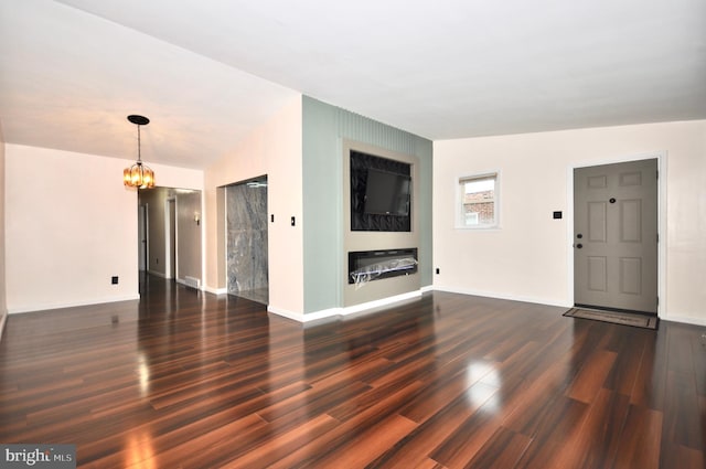 8922 Brous Ave, Philadelphia, PA 19152 - unfurnished living room featuring a chandelier, dark wood-type flooring, and baseboards