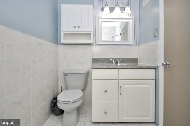 8922 Brous Ave, Philadelphia, PA 19152 - bathroom featuring tile walls, toilet, tile patterned floors, vanity, and wainscoting