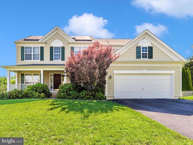 12 Evan Ct, Brunswick, MD 21758 - view of front facade featuring asphalt driveway, a front lawn, roof mounted solar panels, and covered porch