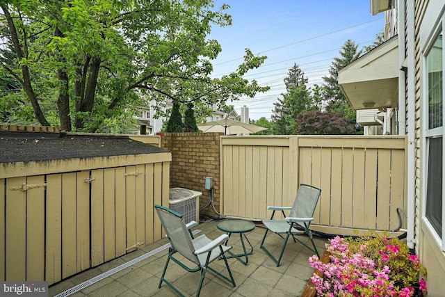view of patio with fence, a storage shed, and cooling unit
