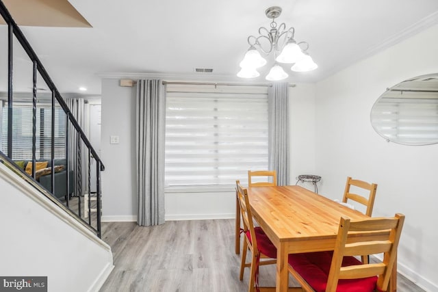dining space featuring a chandelier, wood finished floors, stairway, crown molding, and baseboards