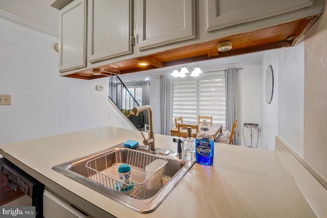 kitchen featuring a sink, light countertops, dishwashing machine, and ornamental molding
