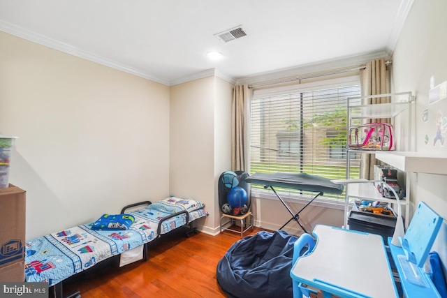 bedroom featuring crown molding, wood finished floors, and baseboards