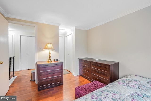 bedroom with wood finished floors and ornamental molding