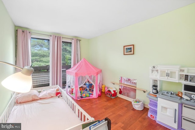 bedroom with wood finished floors and baseboards