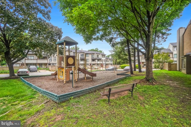 communal playground featuring a lawn and a residential view