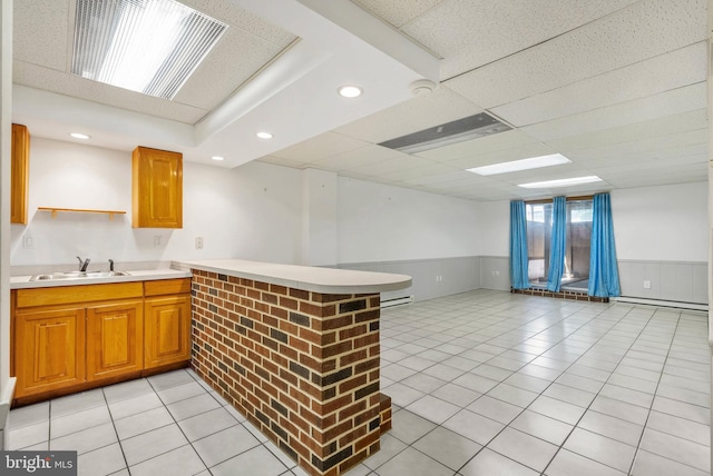643 Saint Anthony Ln, Upper Darby, PA 19082 - kitchen featuring a sink, a peninsula, open floor plan, light tile patterned floors, and light countertops