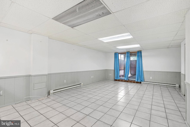 643 Saint Anthony Ln, Upper Darby, PA 19082 - spare room with baseboard heating, wainscoting, a paneled ceiling, and light tile patterned floors