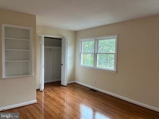 13 E Cliff St, Alexandria, VA 22301 - unfurnished bedroom featuring baseboards, wood finished floors, and a closet