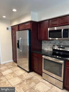 13 E Cliff St, Alexandria, VA 22301 - kitchen featuring appliances with stainless steel finishes, reddish brown cabinets, tasteful backsplash, dark countertops, and recessed lighting